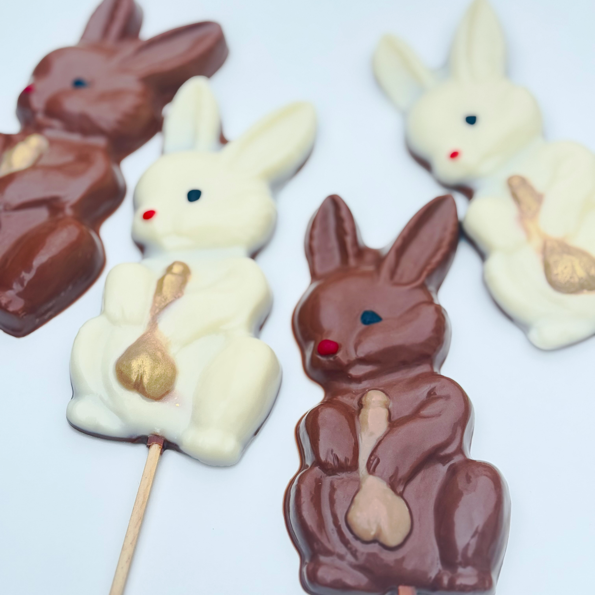 Limited edition Belgian chocolate bunny lollies – funny adult Easter gifts in milk, white, and bueno-style with golden surprise.